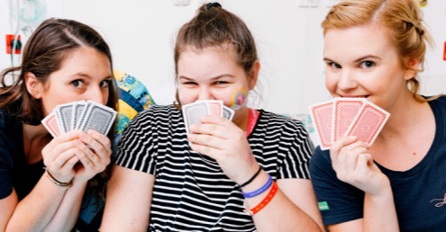 Three young girls playing cards